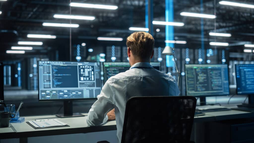 Data analytics consultant working on a computer in a modern high tech office.