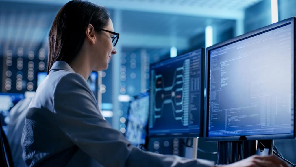 Female data engineer working in a monitoring room.