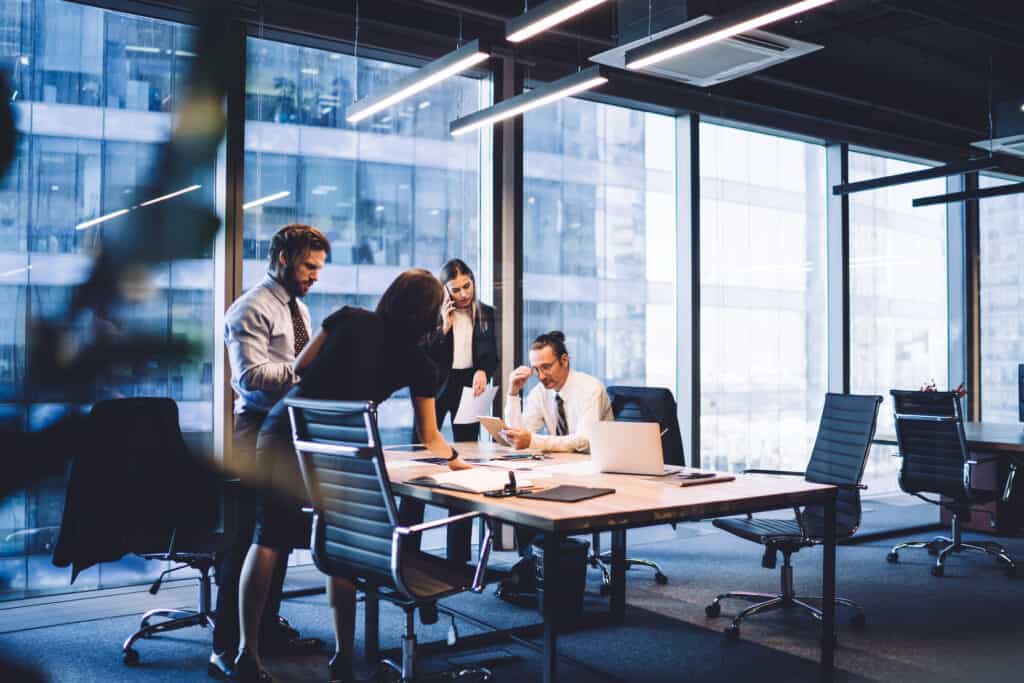 Corporate employees are in an office in a high rise building hard at work.